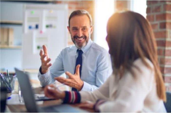 A man and woman have a laugh in the office