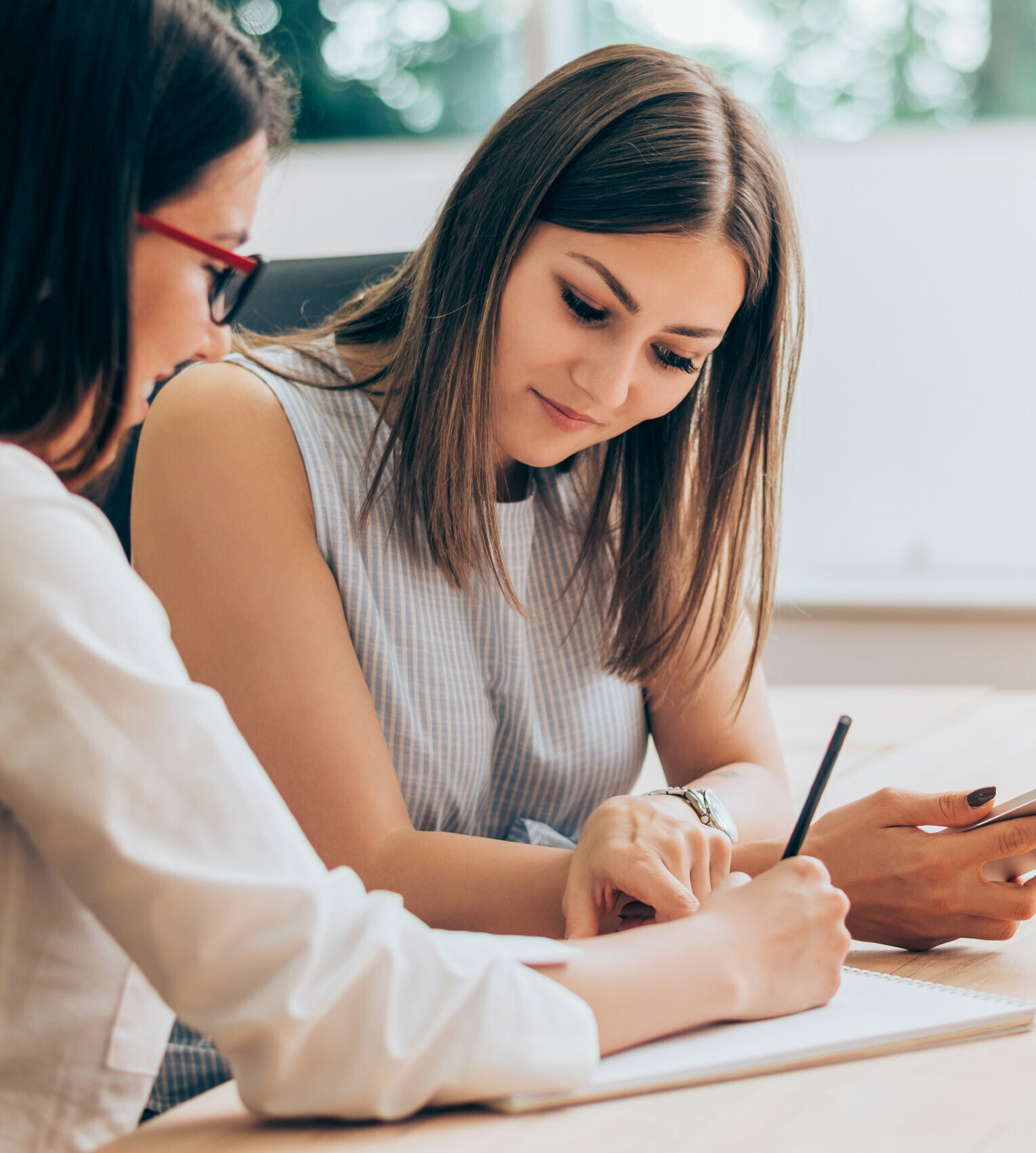 Two female colleagues in office working together.