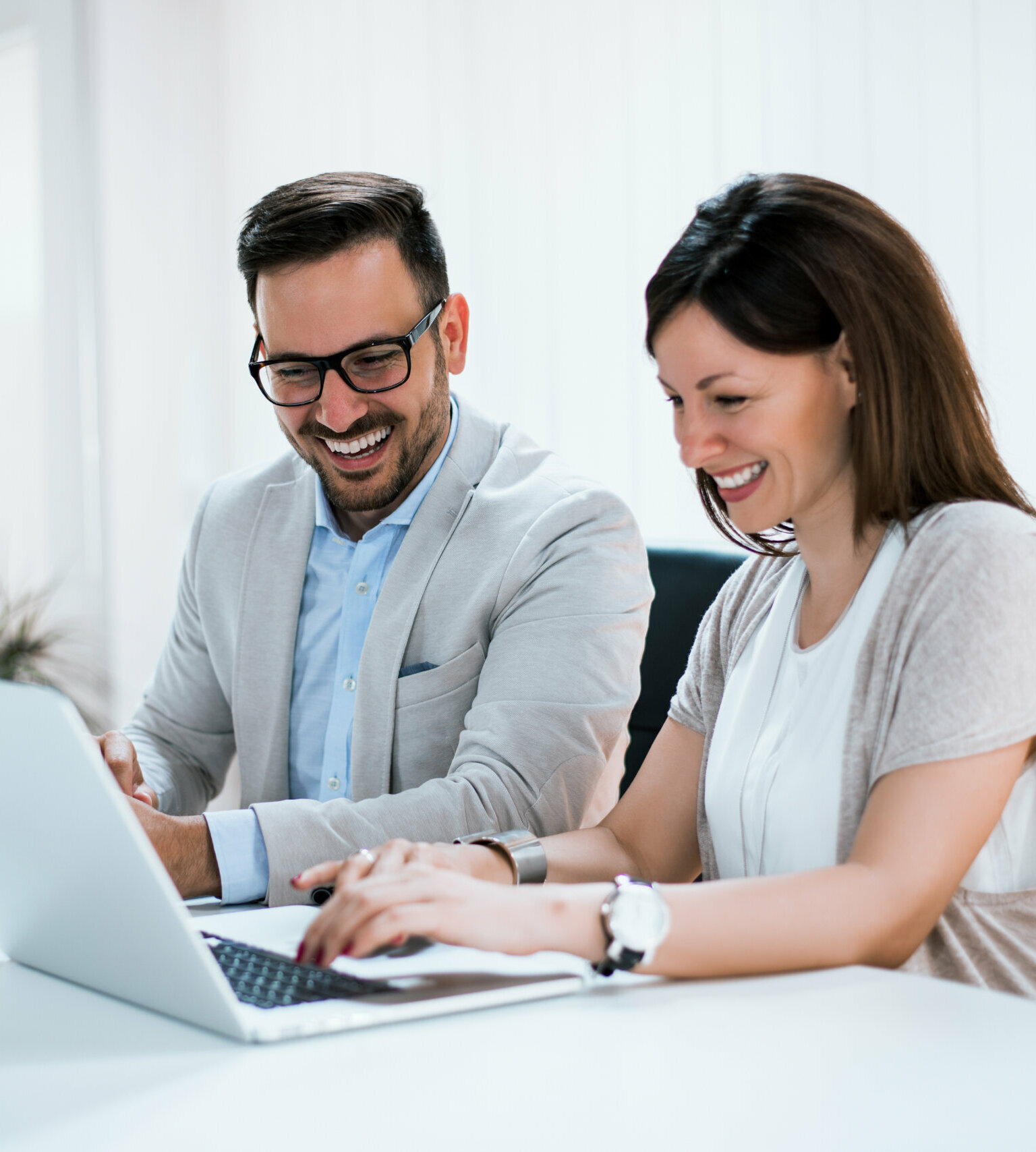 Business people working together in bright office, sitting at desk.